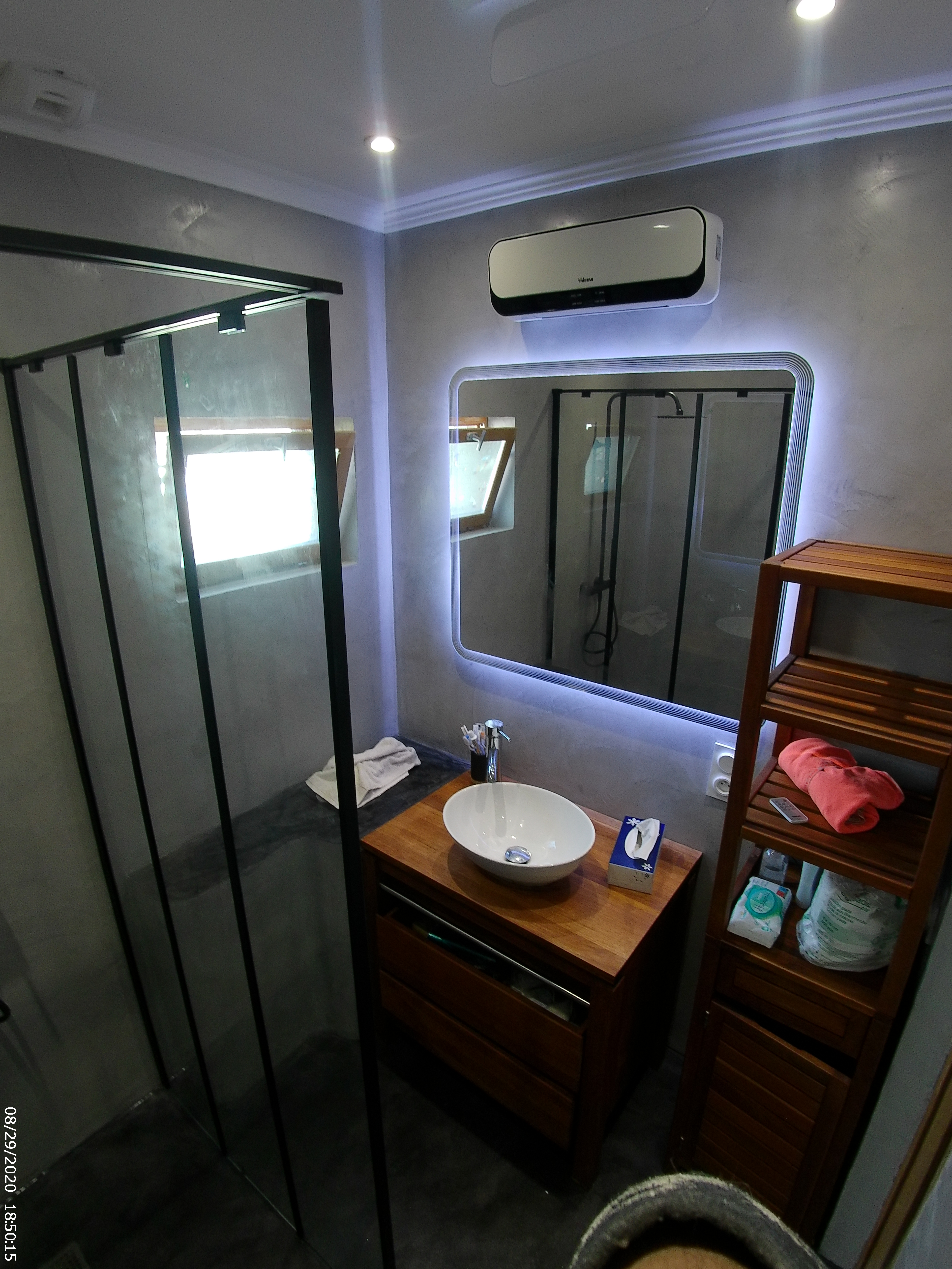 murs minéraux, bois et miroir lumineux.