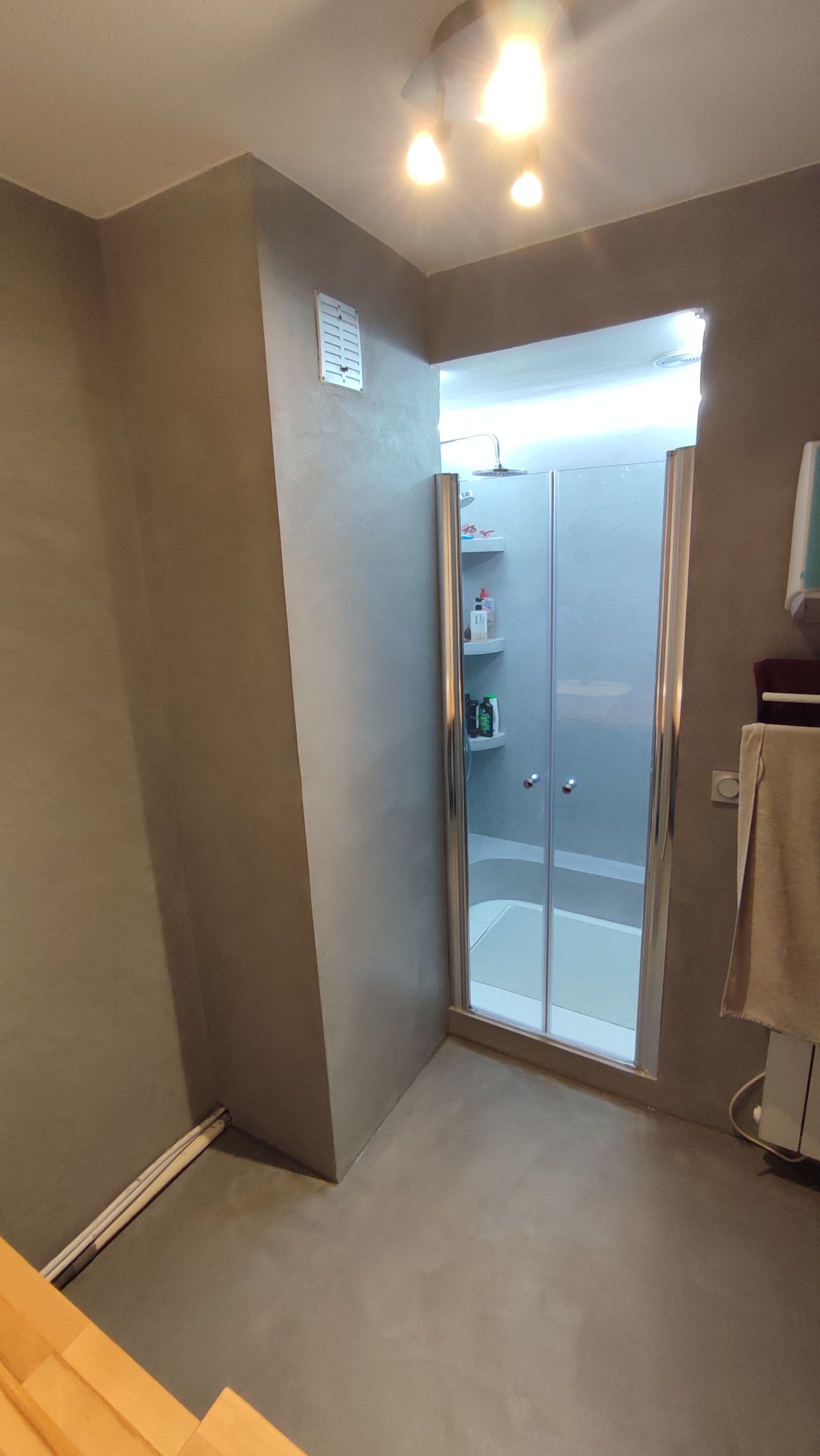 Après — la nouvelle douche trouve sa place dans l’espace réorganisé.