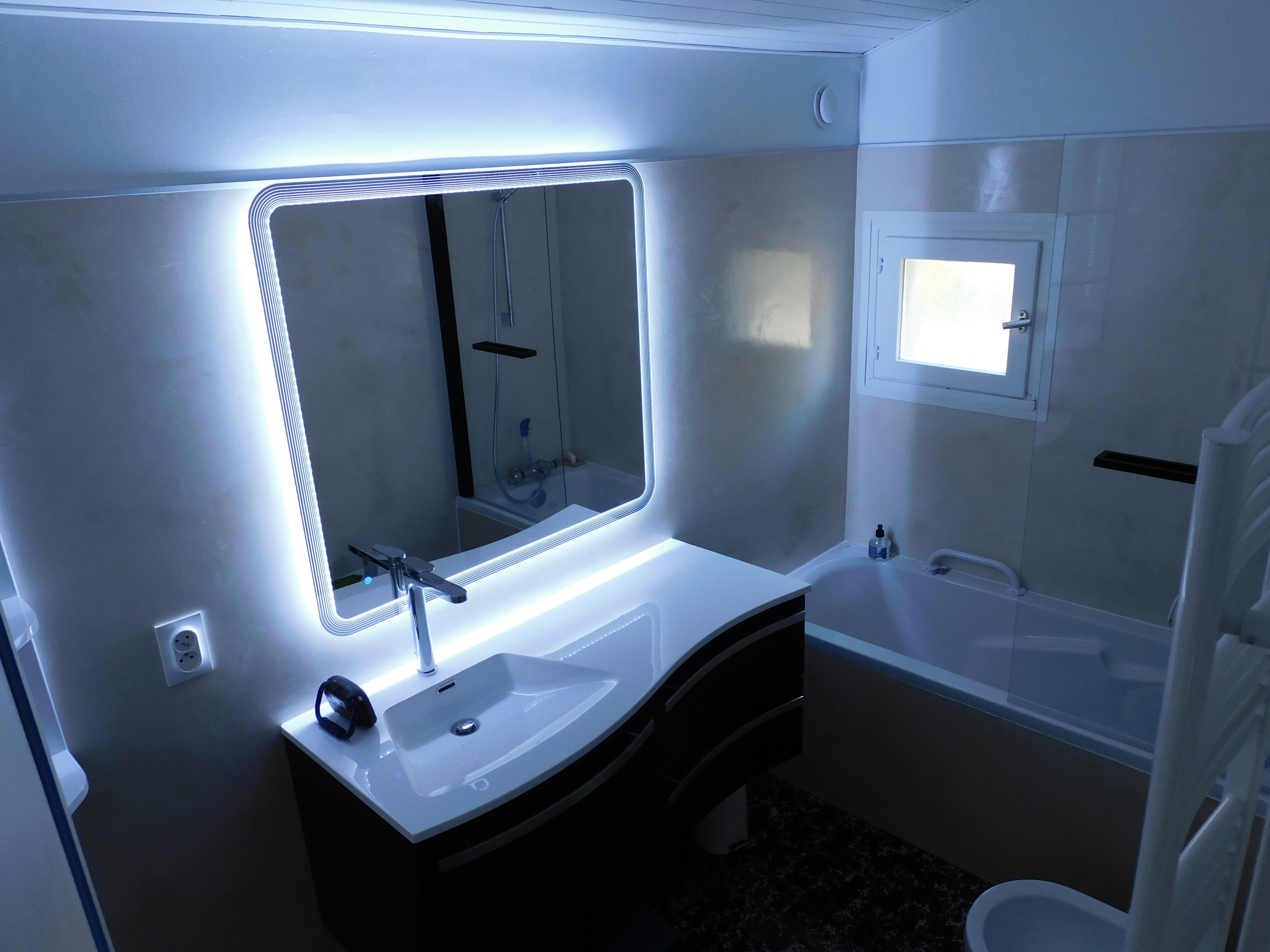 surfaces minérales, meuble vasque et miroir lumineux.