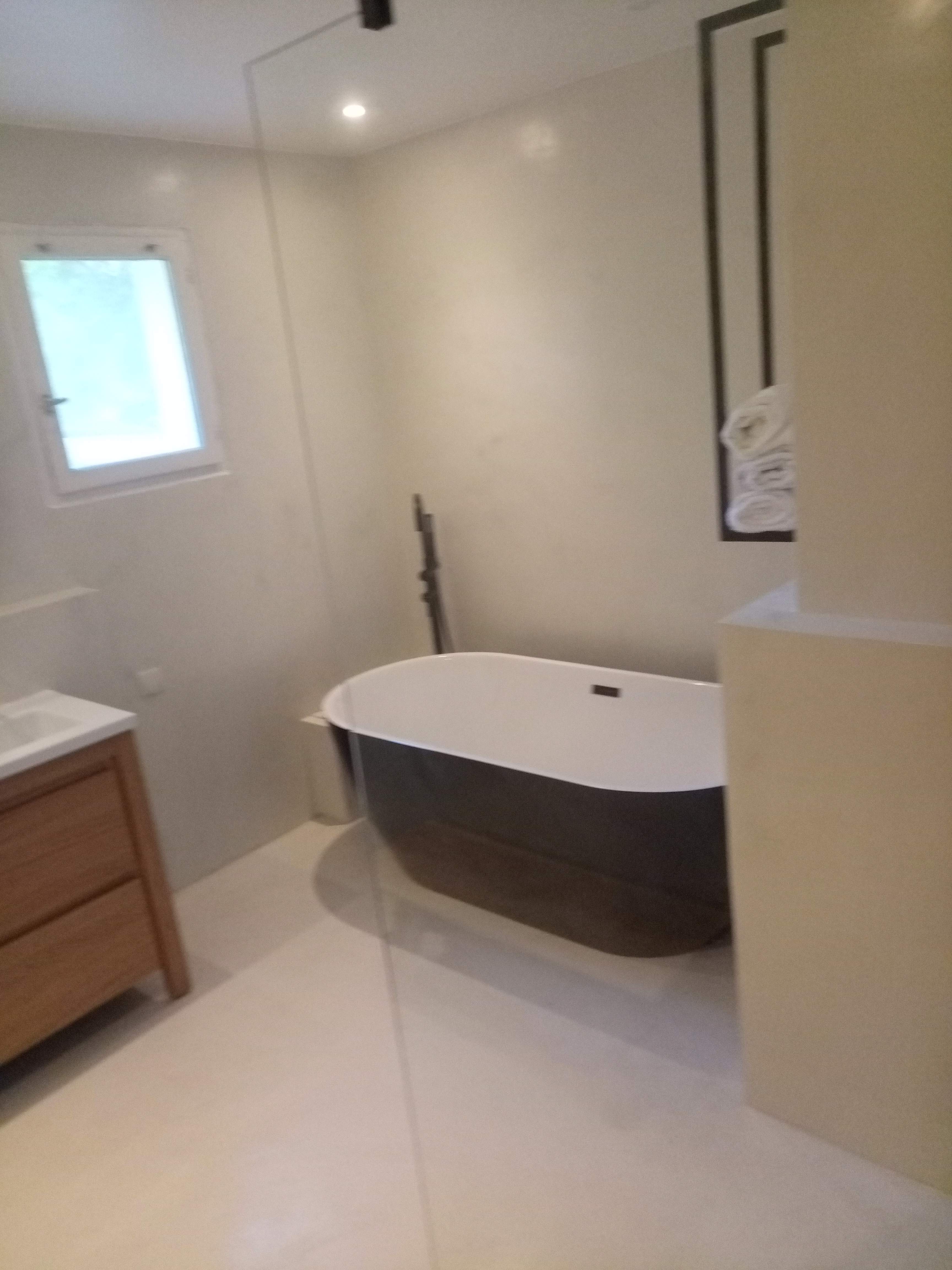 une baignoire îlot dans un décor minéral clair.