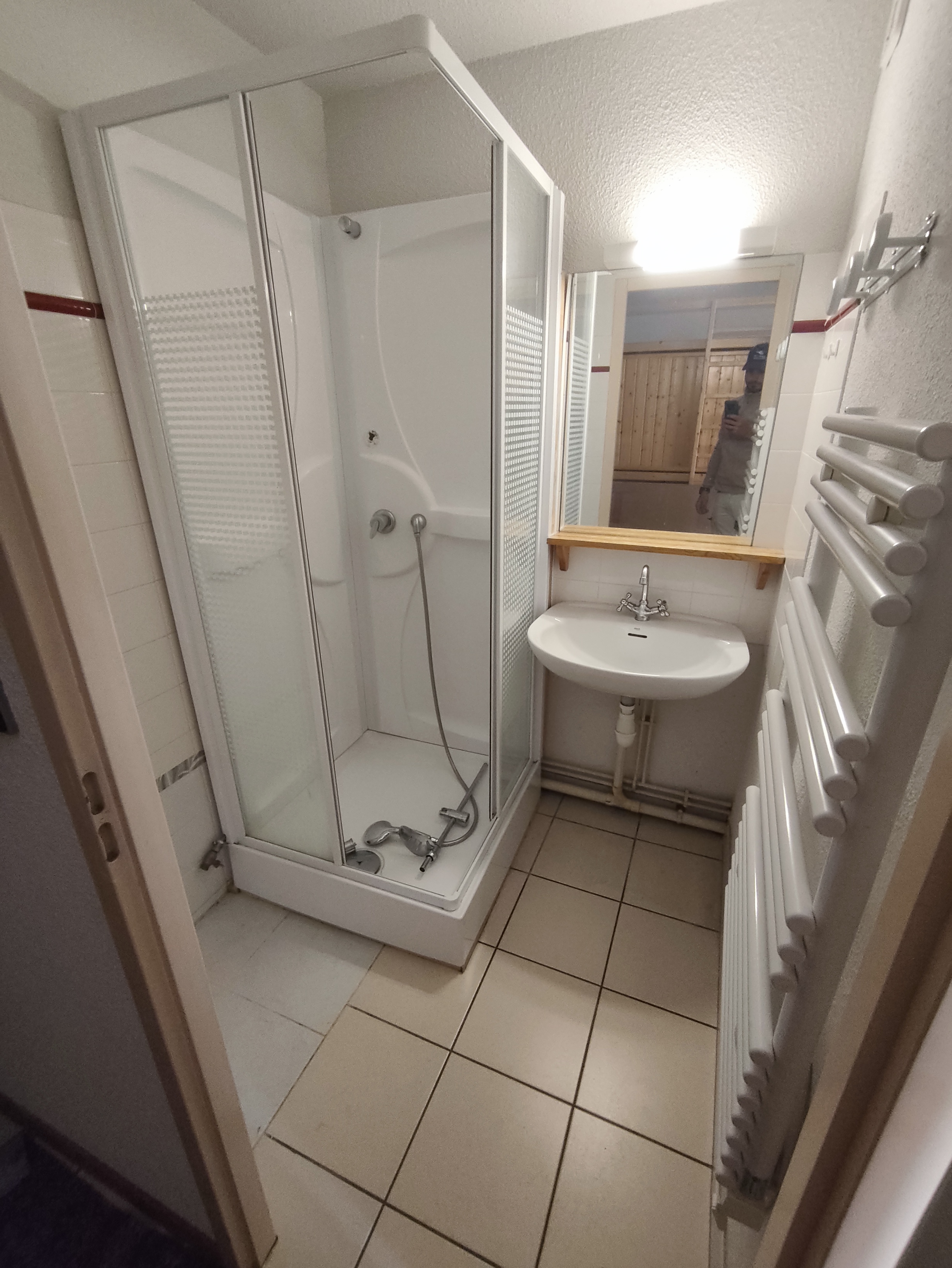 une cabine de douche et un petit lavabo.