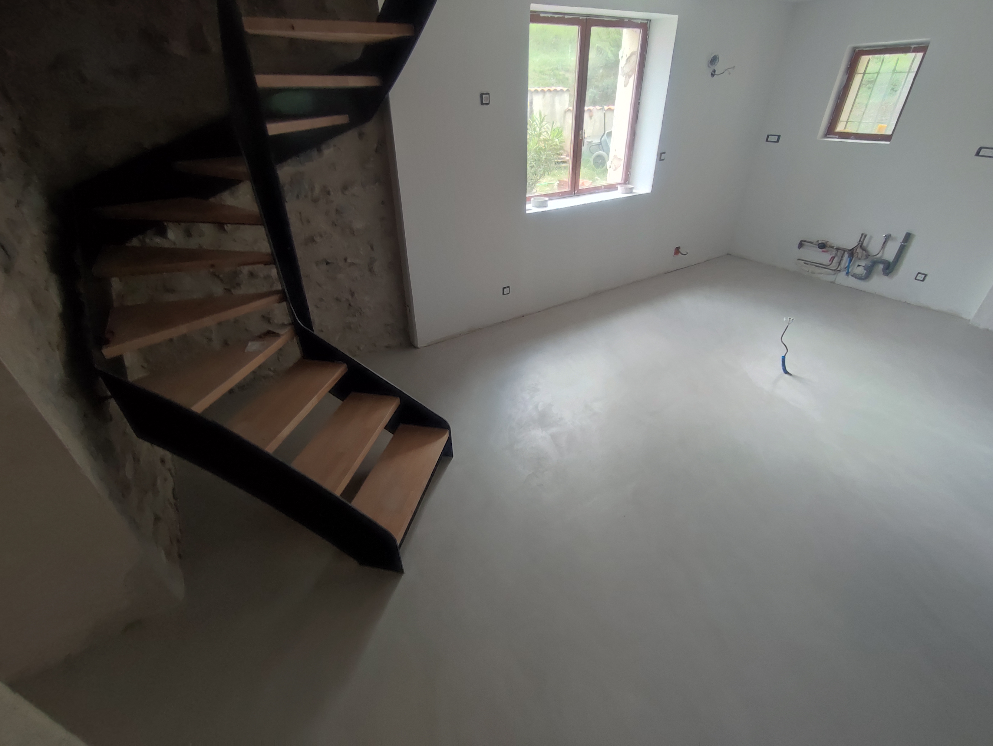 un sol minéral clair au pied de l’escalier.