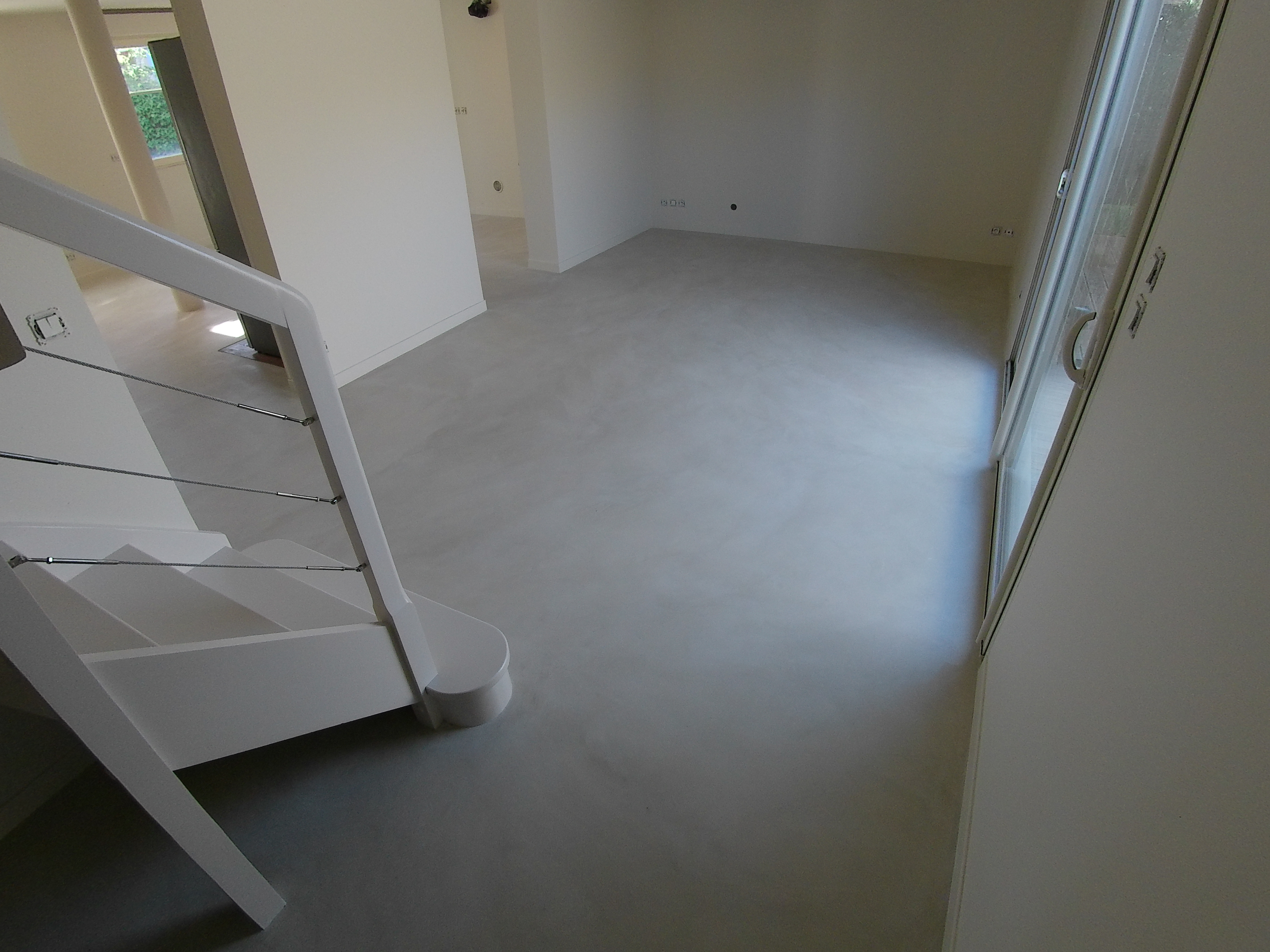 une surface minérale claire près de l’escalier.