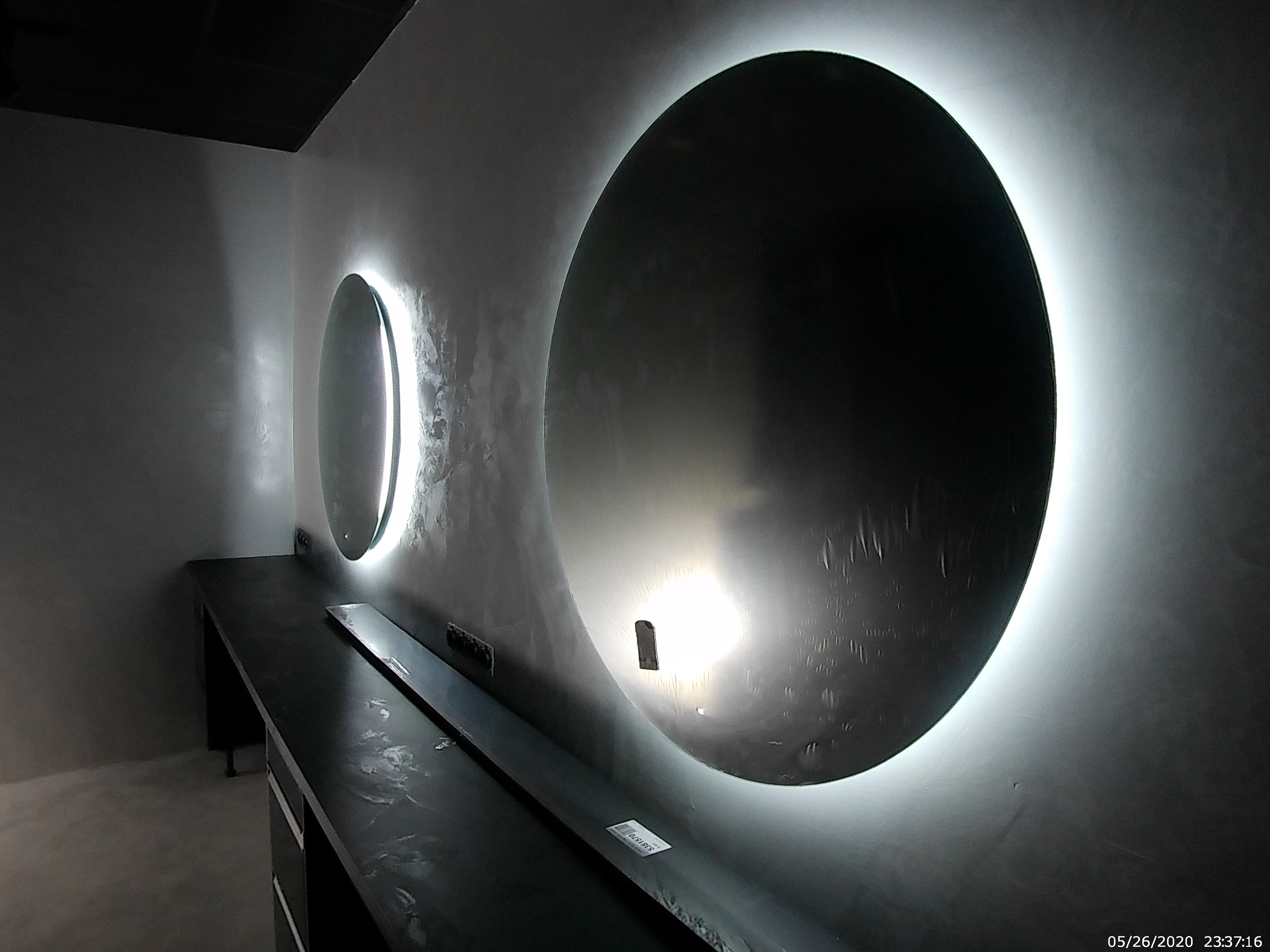Les miroirs rétroéclairés révèlent les nuances du mur sombre.
