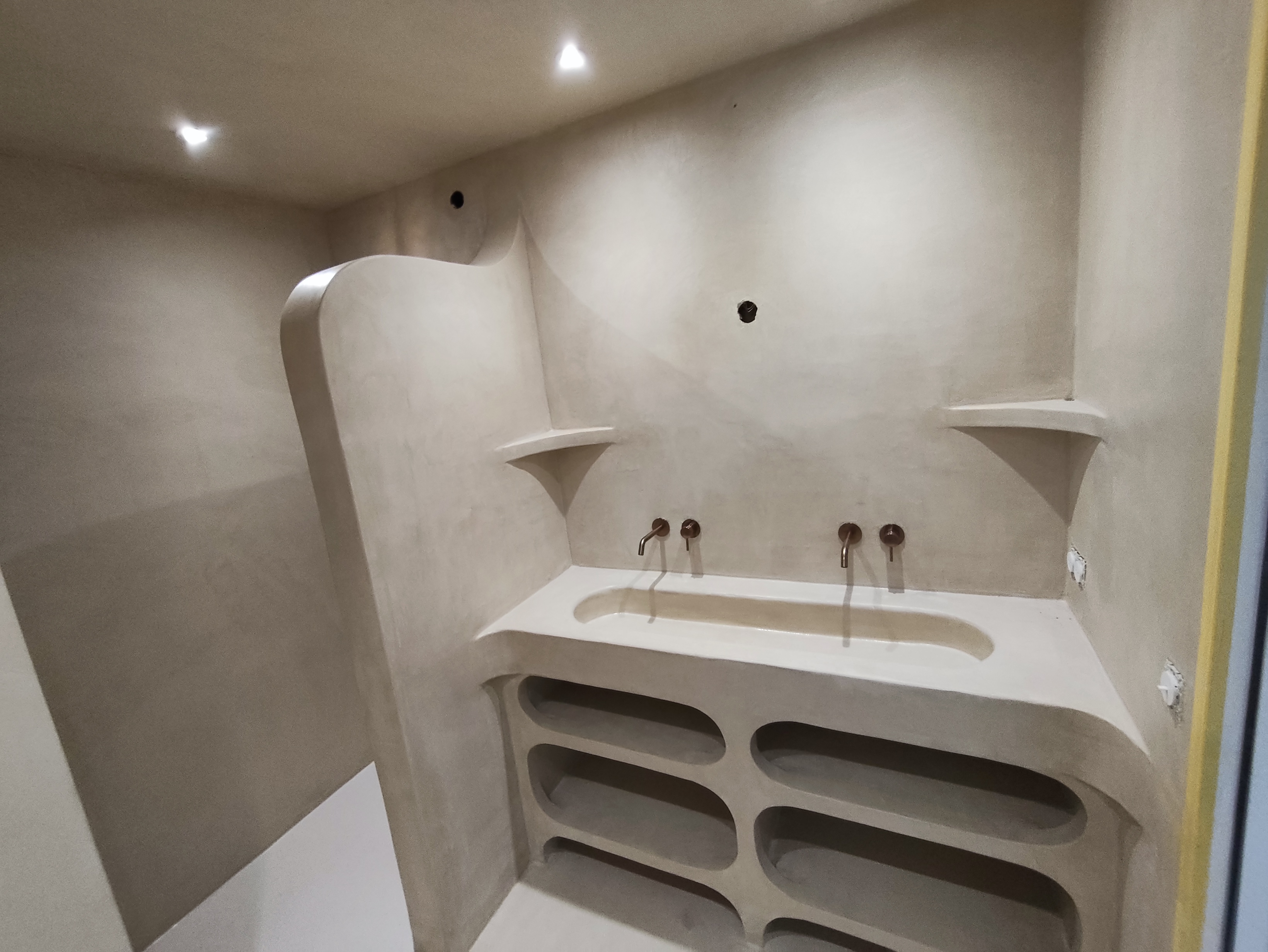 Salle d’eau à Saint-Jean-le-Vieux avec meuble minéral à rangements arrondis, vasque intégrée et douche